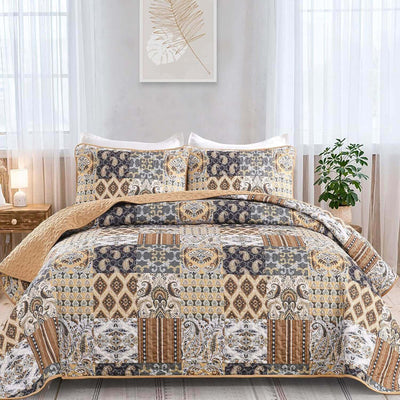 A colorful floral patterned cotton bedspread set on a bed, with a variety of matching and contrasting pillows, in a room with wooden furniture and a lamp.