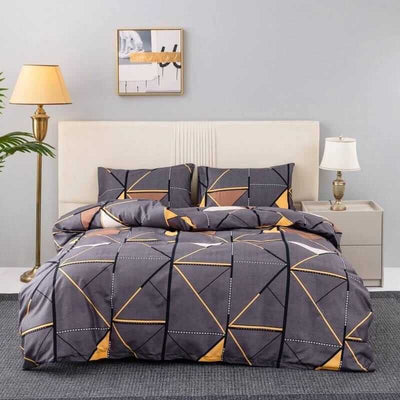 Geometric patterned comforter set on a bed in a bedroom with lamps and decor.