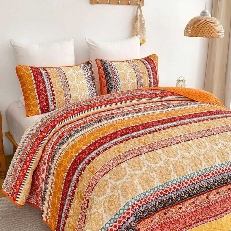 Bed with patterned quilt and pillows in a bedroom setting