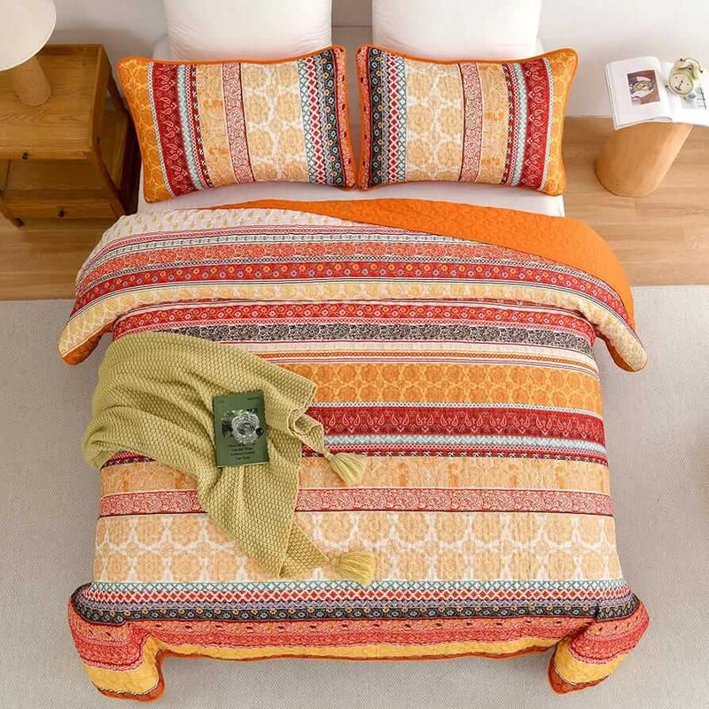 Bed with patterned quilt and pillows in a bedroom setting