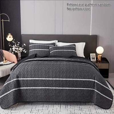 Bed with gray and white striped bedding and pillows in a bedroom setting.