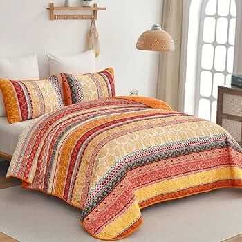 Bed with patterned quilt and pillows in a bedroom setting