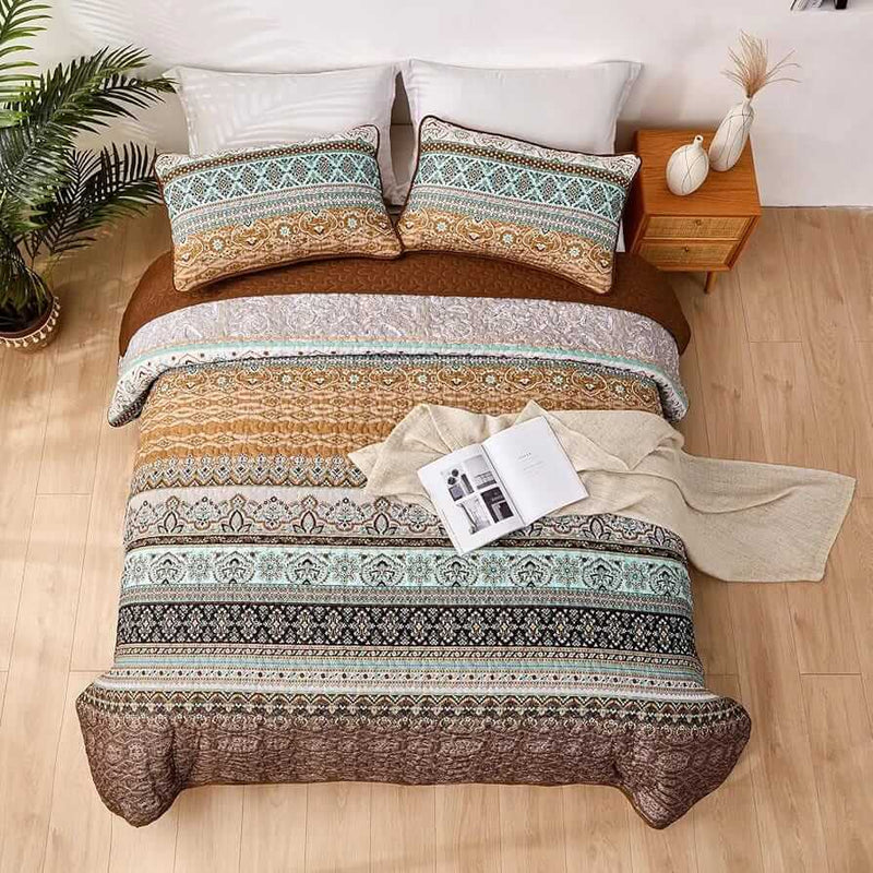 Bed with patterned quilt and pillows in a bedroom setting