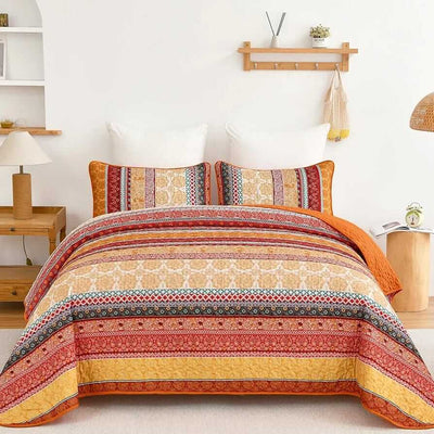Bed with patterned quilt and pillows in a bedroom setting