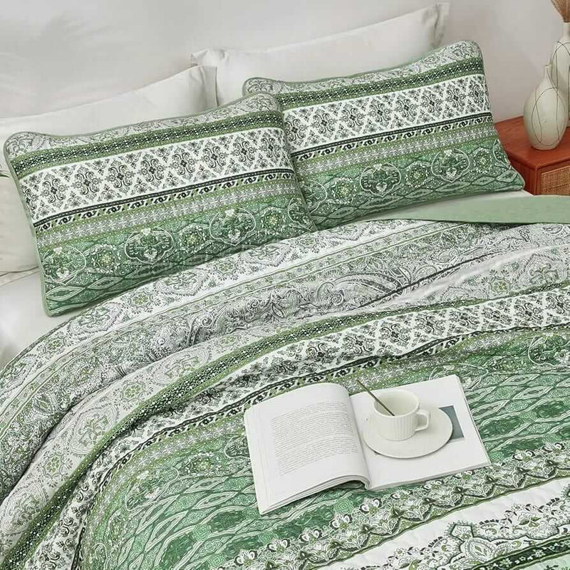 Bed with patterned quilt and pillows in a bedroom setting