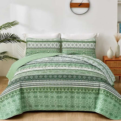 Bed with patterned quilt and pillows in a bedroom setting