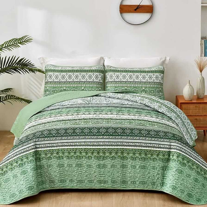 Bed with patterned quilt and pillows in a bedroom setting