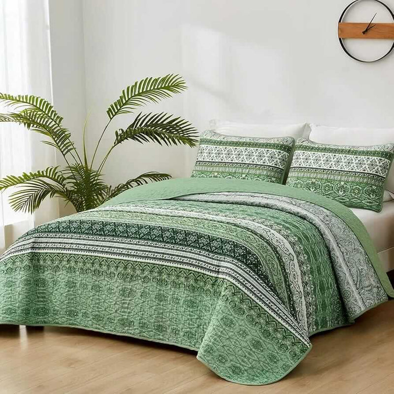 Bed with patterned quilt and pillows in a bedroom setting
