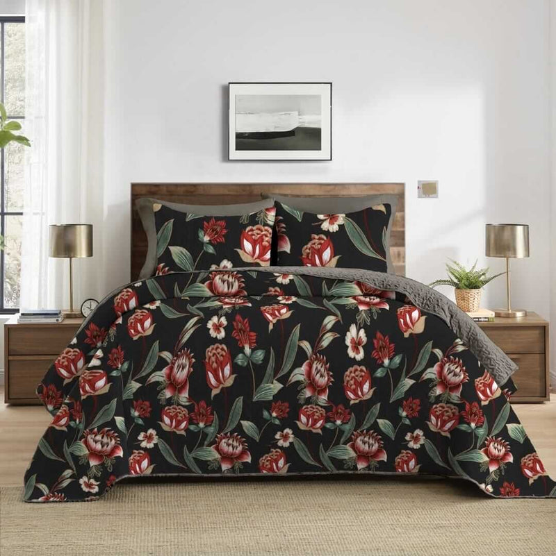 Floral patterned comforter set on a bed in a bedroom with lamps and decor.