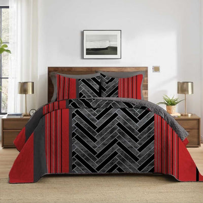 Bed with red and gray patterned comforter in a bedroom setting