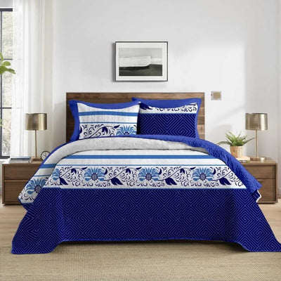 Blue and white floral patterned comforter set on a bed in a bedroom.