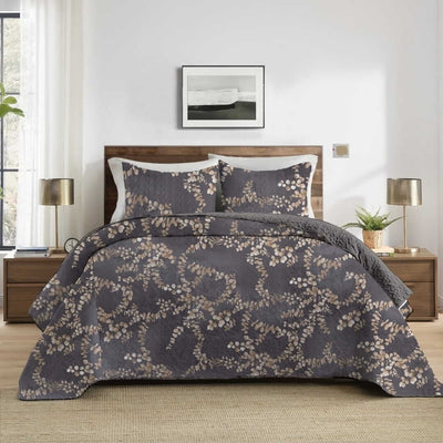 Floral patterned comforter on a bed in a bedroom setting with lamps and decor.