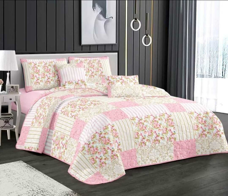 Pink floral quilt set on a bed in a bedroom setting