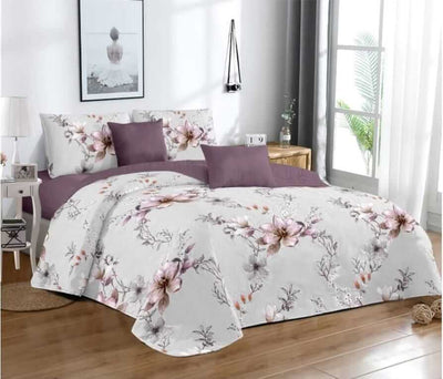 Floral bedding set on a bed in a bedroom with a window and decor.