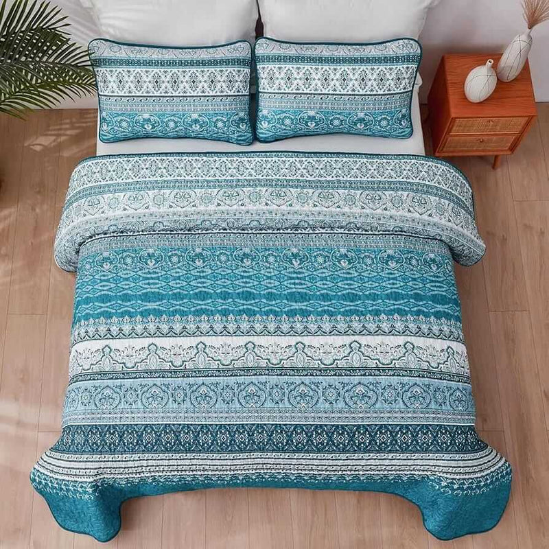 Bed with patterned quilt and pillows in a bedroom setting