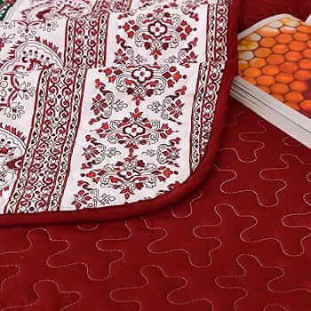 Bed with patterned quilt and pillows in a bedroom setting