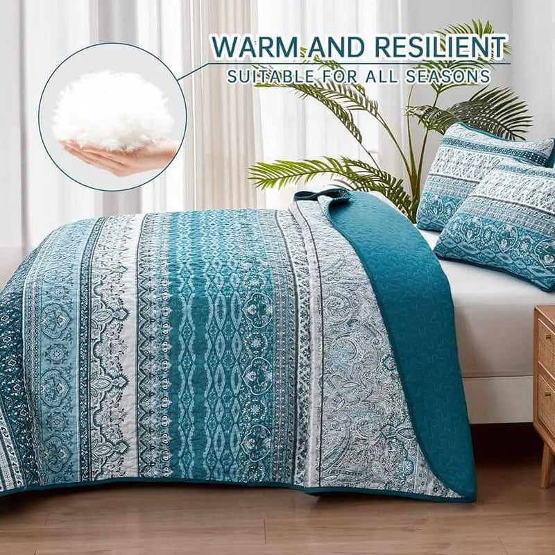 Bed with patterned quilt and pillows in a bedroom setting