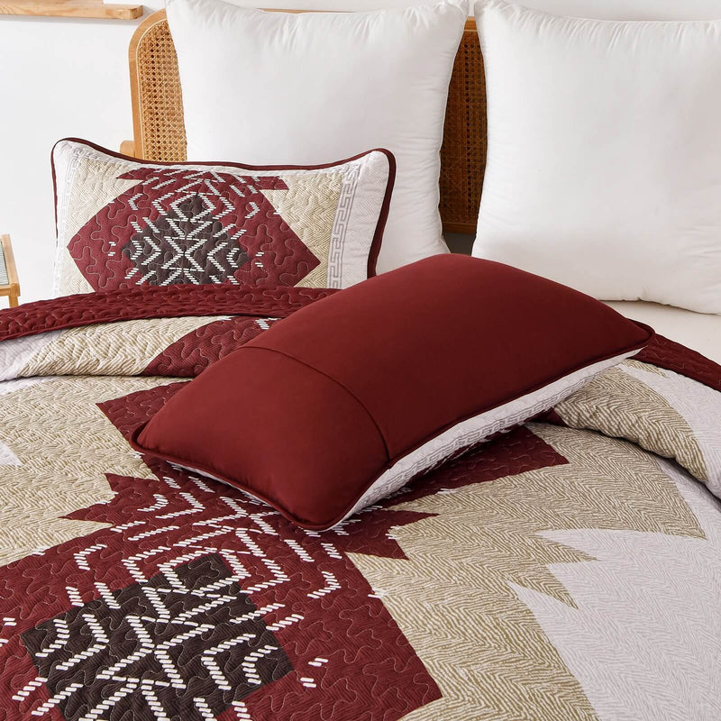 Patchwork quilt set on a bed in a bedroom with a wooden headboard.