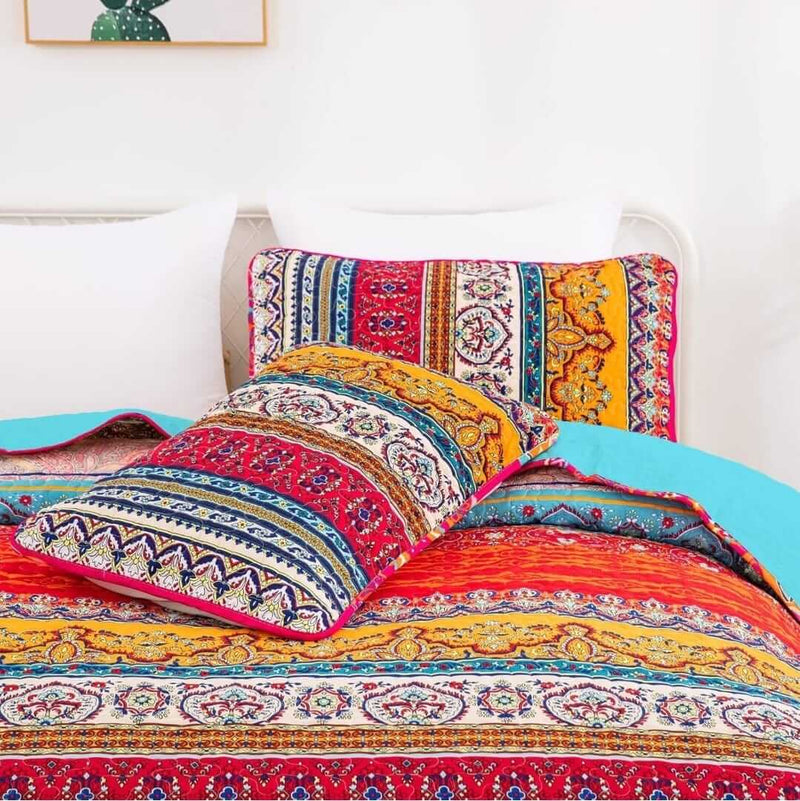 Colorful patterned bedding set on a bed with a white wall in the background