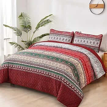 Bed with patterned quilt and pillows in a bedroom setting