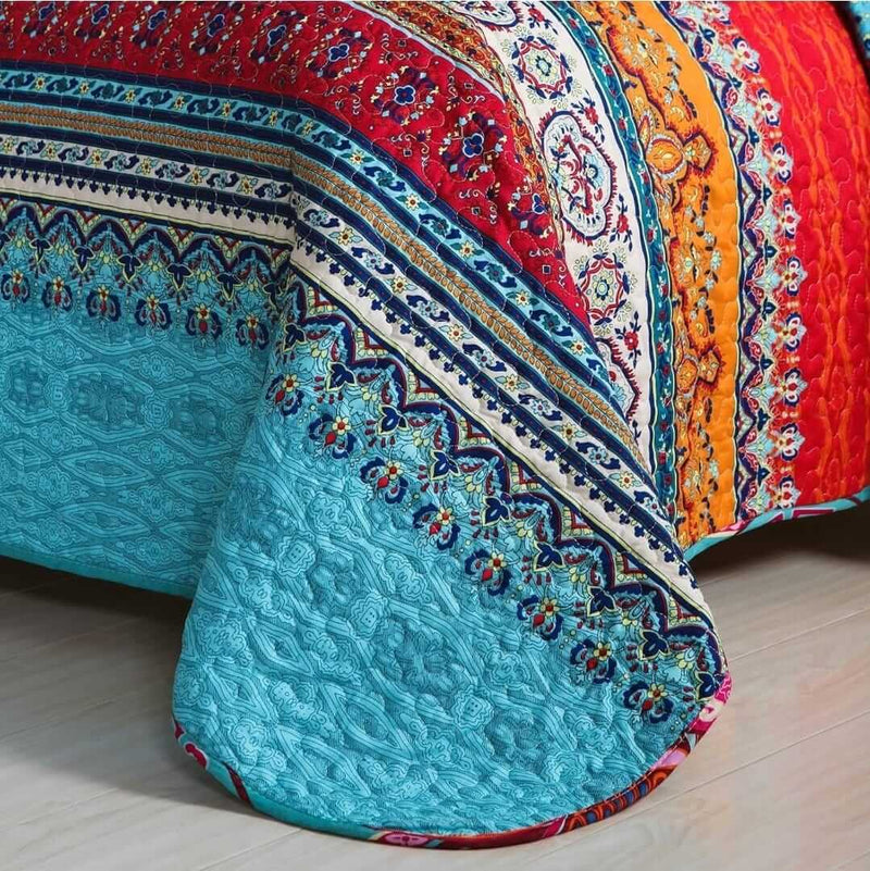 Colorful quilt with intricate patterns on a wooden floor