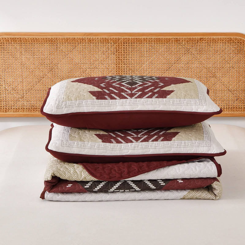 Patchwork quilt set on a bed in a bedroom with a wooden headboard.