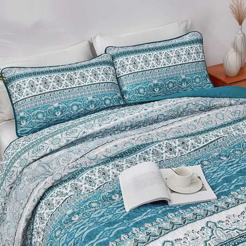Bed with patterned quilt and pillows in a bedroom setting