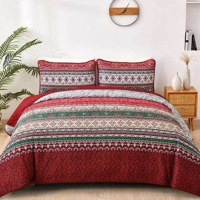 Bed with patterned quilt and pillows in a bedroom setting