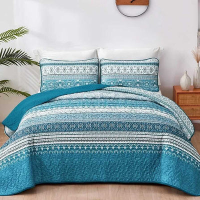 Bed with patterned quilt and pillows in a bedroom setting