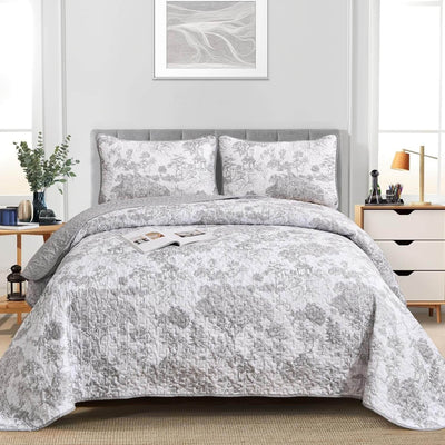 Gray floral patterned comforter set on a bed in a bedroom setting.