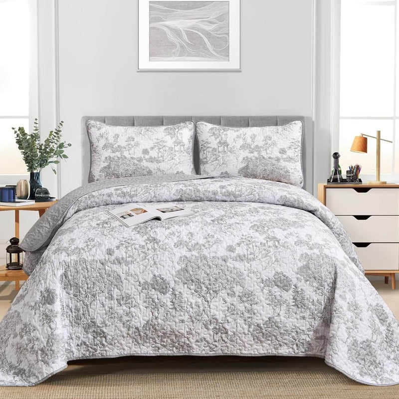 Gray floral patterned comforter set on a bed in a bedroom setting.