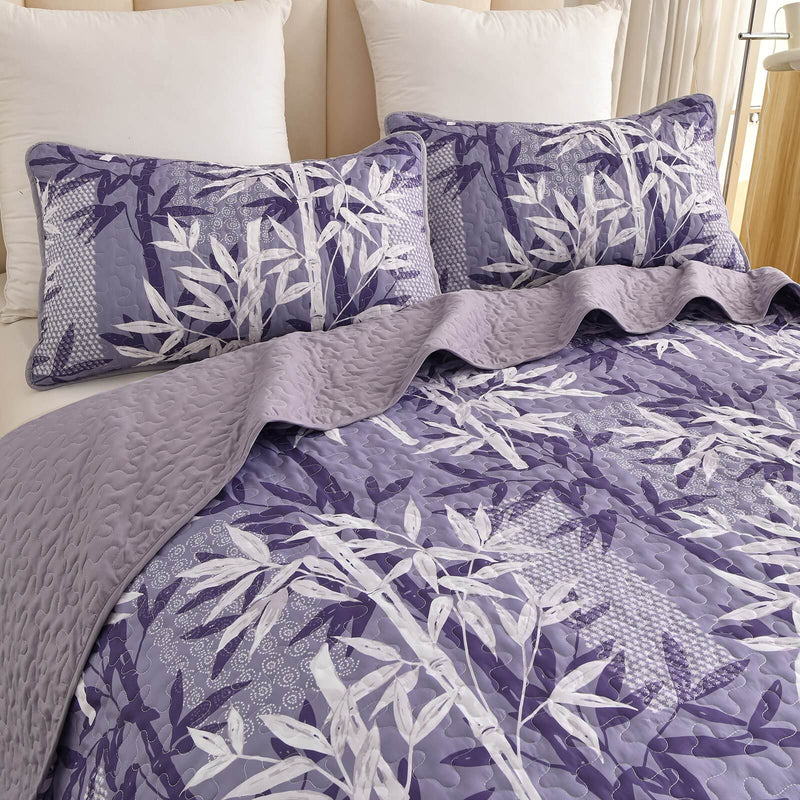 Bed with a colorful quilt and pillows in a bedroom setting.