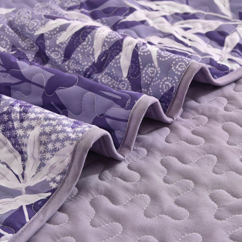 Bed with a colorful quilt and pillows in a bedroom setting.