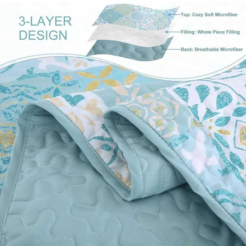 Blue and green patchwork quilt set on a bed in a bedroom.