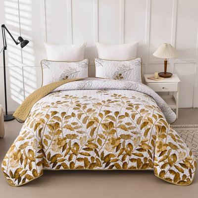 Bed with gold leaf patterned comforter in a bedroom setting