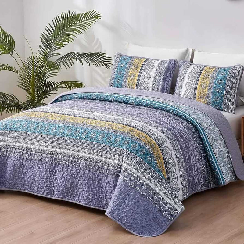Bed with a colorful quilt and pillows in a bedroom setting.