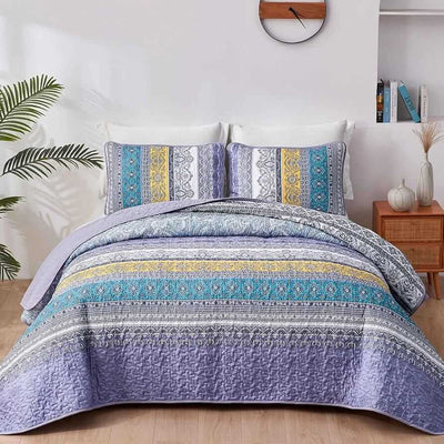 Bed with a colorful quilt and pillows in a bedroom setting.