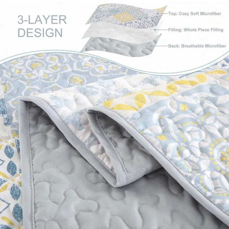 Patchwork quilt set on a bed in a bedroom with a wooden headboard.