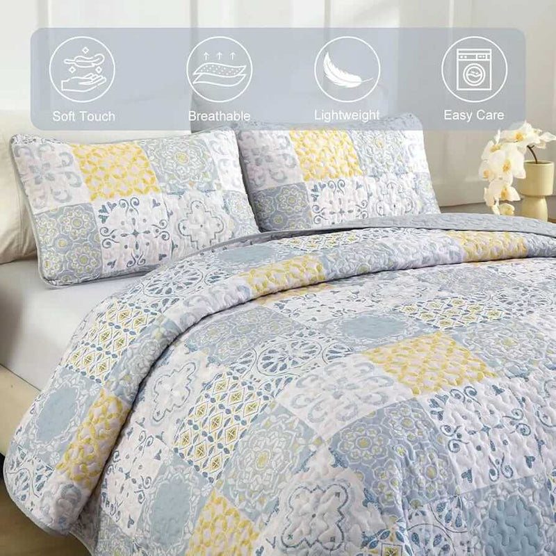 Patchwork quilt set on a bed in a bedroom with a wooden headboard.