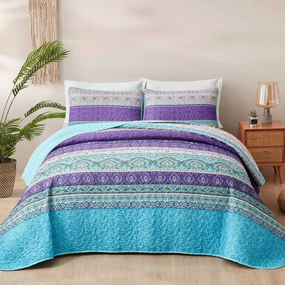 Bed with a colorful quilt and pillows in a bedroom setting.