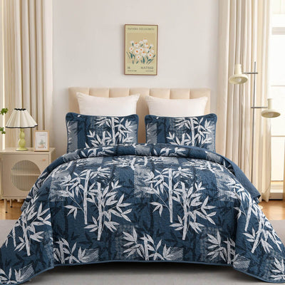 Blue and white leaf-patterned comforter set on a bed in a bedroom.
