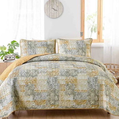 Patchwork quilt set on a bed in a bedroom with a wooden headboard.