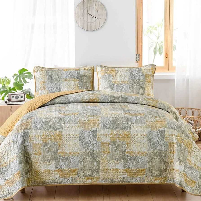 Patchwork quilt set on a bed in a bedroom with a wooden headboard.