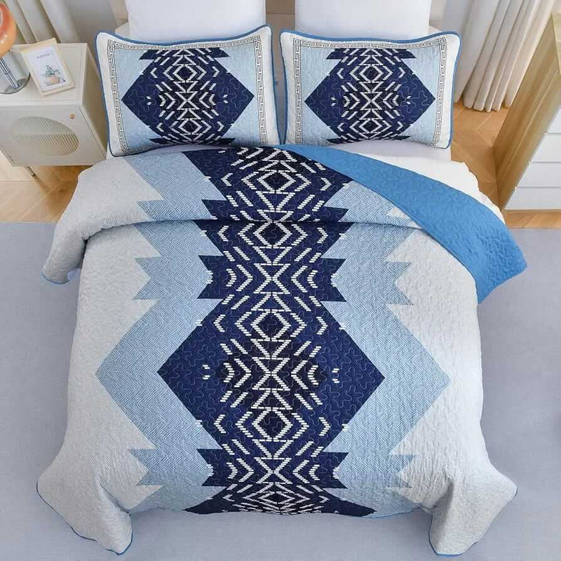 Patchwork quilt set on a bed in a bedroom with a wooden headboard.
