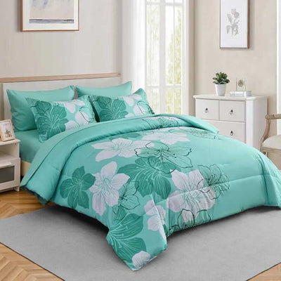 Teal floral bedding set on a bed in a bedroom with light-colored walls and furniture.