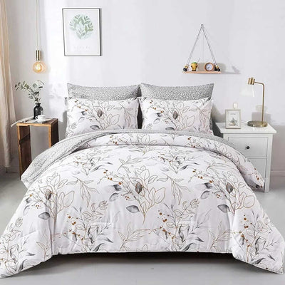 Floral patterned comforter set on a bed in a bedroom setting with decor elements.