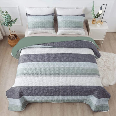 Striped quilt set on a bed in a bedroom with a nightstand and decor items.