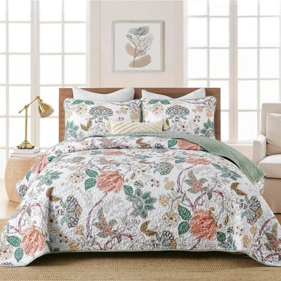 Floral bedding set on a bed in a bedroom with a lamp and artwork on the wall.