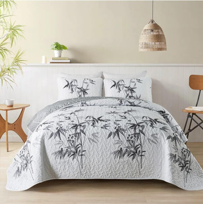 Bed with bamboo leaf patterned bedding in a bedroom setting.