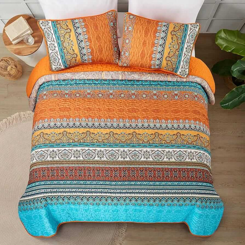 Bed with patterned quilt and pillows in a bedroom setting
